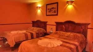a hotel room with two beds in a room at Hotel Real del Valle in San Cristóbal de Las Casas