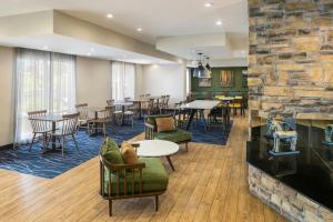 a lobby of a hotel with tables and chairs at Fairfield Inn by Marriott Richmond in New Paris