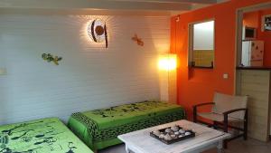 a room with two beds and a table at Location Marigot in Terre-de-Haut