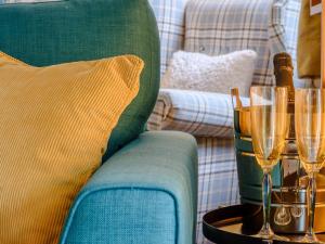 a green couch with champagne glasses on a table at Cherry Tree Corner in Ashbourne