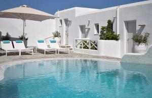 a swimming pool with chairs and an umbrella at Kanale's Rooms & Suites in Naousa
