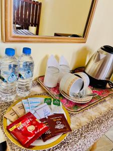 a table with a plate of food and water bottles at Zentara Hills in Haputale