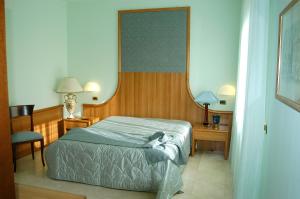 1 dormitorio con cama y espejo en Hotel Royal, en Vasto