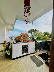 a balcony with a fireplace and flowers on it at Zentara Hills in Haputale