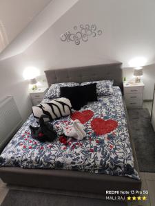 a bedroom with a bed with two hearts on it at Apartment Mali Raj -Stunning Gacka River View-Peaceful Nature Escape in Otočac