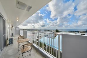 a balcony with two chairs and a view of the ocean at Sea Side TOYA in Yomitan