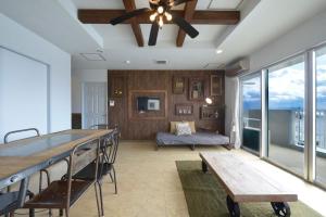 a living room with a ceiling fan and a couch at Sea Side TOYA in Yomitan