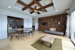 a living room with a ceiling fan and a table at Sea Side TOYA in Yomitan
