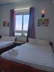 a bedroom with two beds and a window at Thanh Tran Guesthouse Lý Sơn in Ly Son