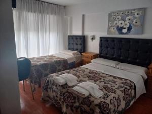 a hotel room with two beds with towels on them at Hotel Bristol in Córdoba