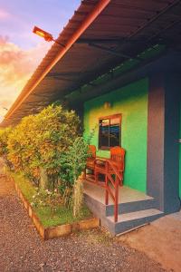 a house with a bench on the side of it at ใบตองรีสอร์ท in Ban Thung Kha Chomphu
