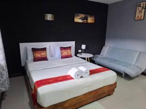 a bedroom with a large bed and a couch at ใบตองรีสอร์ท in Ban Thung Kha Chomphu +3 photos
