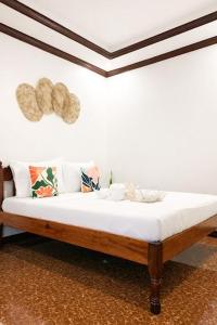 a bed in a room with a white wall at PEPAYEN Homestay in General Luna
