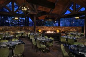 a restaurant with tables and chairs and a fireplace at The Ritz-Carlton, Bachelor Gulch in Beaver Creek