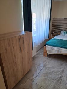 a bedroom with a bed and a wooden cabinet at Szabó Vendégház in Bükkszék