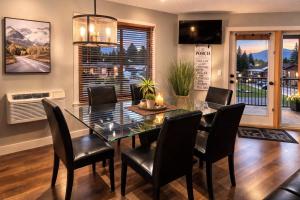 a dining room with a glass table and black chairs at Summit View Alpine Retreat in Radium Hot Springs