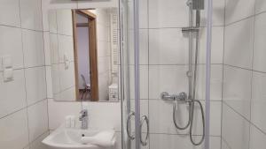 a white bathroom with a shower and a sink at Przestronny Apartament typu Studio, GARAŻ W CENIE in Wrocław +5 photos