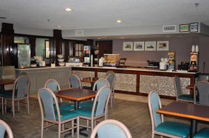 un ristorante con tavoli e sedie e un bar di Dunes Express Inn and Suites a Hart