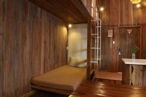 a bed in the corner of a room with wooden walls at Yugen Village in Khu Chi Lăng