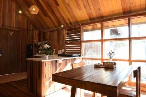 a kitchen with a wooden table and a large window at Yugen Village in Khu Chi Lăng