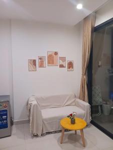 a white bedroom with a bed and a table at GÂY THƯƠNG NHỚ Homestay Phòng trong vinhome grand park tên cũ I love vinhome grand park in Gò Công