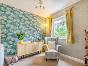 a living room with a chair and a cabinet and a window at Cherry Tree Corner in Ashbourne