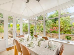 a dining room with a table and chairs and windows at Cherry Tree Corner in Ashbourne +15 photos