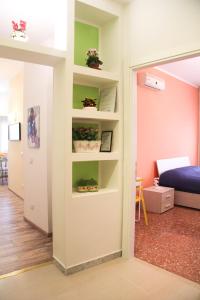 um quarto com paredes verdes e brancas com prateleiras em Maison Velia em Roma