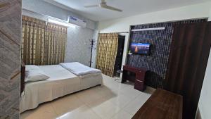 a bedroom with a bed and a tv in it at Sweet Rest Dhaka in Dhaka