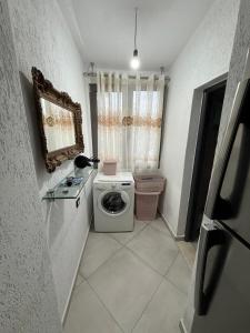 a small bathroom with a toilet and a washing machine at villa Heljos apartaments in Vlorë +44 photos