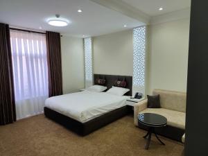 a bedroom with a bed and a couch at SHOHI ZINDA Hotel in Samarkand +32 photos