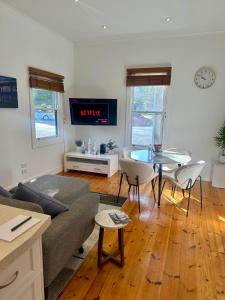 a living room with a couch and a table at Botanical Gardens City Cottage in Geelong