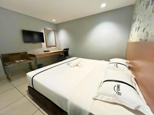 a hotel room with a bed and a television at Seeds Hotel Premier Pudu TRX Kuala Lumpur in Kuala Lumpur