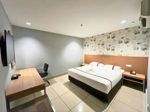 a bedroom with a bed and a desk and a tv at Seeds Hotel Premier Pudu TRX Kuala Lumpur in Kuala Lumpur