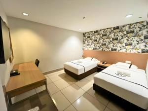 a hotel room with two beds and a flat screen tv at Seeds Hotel Premier Pudu TRX Kuala Lumpur in Kuala Lumpur +42 photos