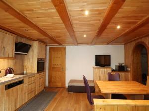 a kitchen with wooden ceilings and a table and a bed at Wohnung in Silbertal nahe Skilift in Silbertal