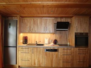 a kitchen with wooden cabinets and a stainless steel refrigerator at Wohnung in Silbertal nahe Skilift in Silbertal