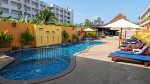 a pool at a hotel with lounge chairs and an umbrella at Kata Silver Sand in Kata Beach