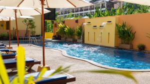 a pool at a hotel with chairs and umbrellas at Kata Silver Sand in Kata Beach