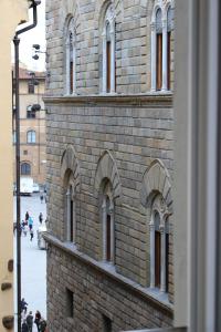 a tall brick building with people walking on the street at Olga's House in Florence