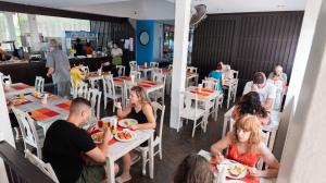 a group of people sitting at tables in a restaurant at Kata Silver Sand in Kata Beach