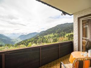 ein Balkon mit Tisch und Blick auf die Berge in der Unterkunft Cozy Apartment in Afritz am See near Gerlitzen Ski Area in Afritz