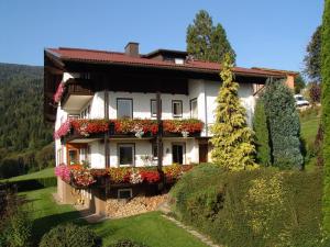 ein Haus mit Blumenkästen an der Seite in der Unterkunft Cozy Apartment in Afritz am See near Gerlitzen Ski Area in Afritz
