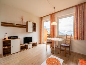 ein Wohnzimmer mit einem Tisch und einem großen Fenster in der Unterkunft Cozy Apartment in Afritz am See near Gerlitzen Ski Area in Afritz