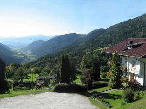 Ein Haus auf einem Hügel mit Bergen im Hintergrund in der Unterkunft Cozy Apartment in Afritz am See near Gerlitzen Ski Area in Afritz + 30 Fotos