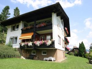ein Gebäude mit Blumenkästen auf den Balkonen in der Unterkunft Cozy Apartment in Afritz am See near Gerlitzen Ski Area in Afritz