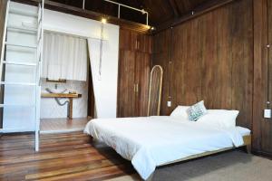 a bedroom with a bed with a wooden wall at Yugen Village in Khu Chi Lăng