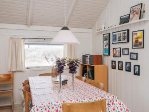 a dining room with a table with flowers on it at 4 star holiday home in Vejers Strand in Vejers Strand