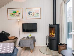 a living room with a fireplace and a tv at 4 star holiday home in Vejers Strand in Vejers Strand