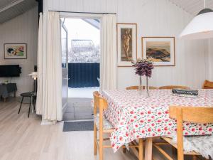 a dining room with a table with flowers on it at 4 star holiday home in Vejers Strand in Vejers Strand